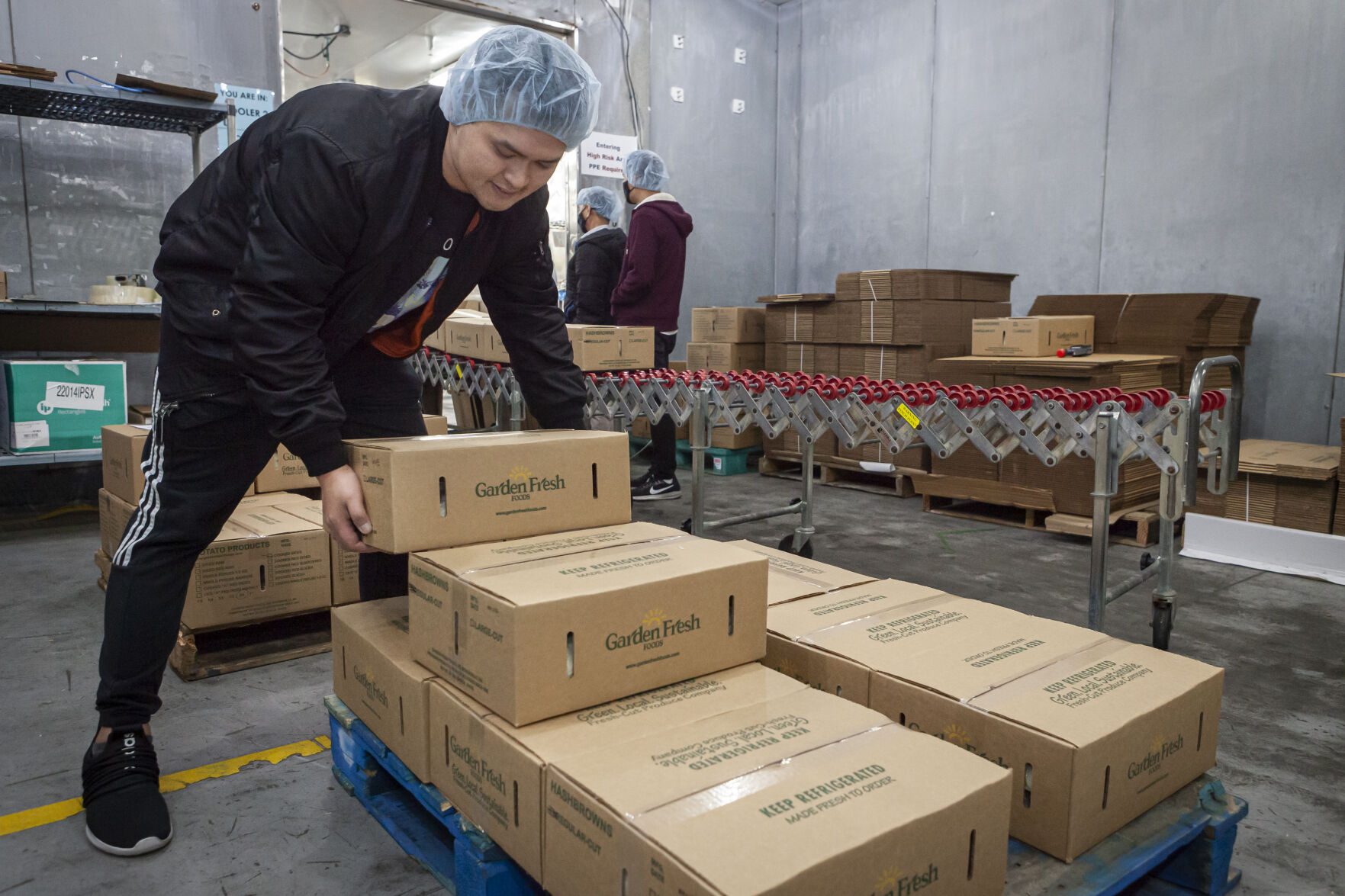 John Nguyen loads boxes of hash browns on a pallet for delivery.